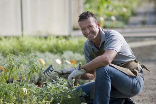 Gardener pruning plants in a well-maintained West Ham garden